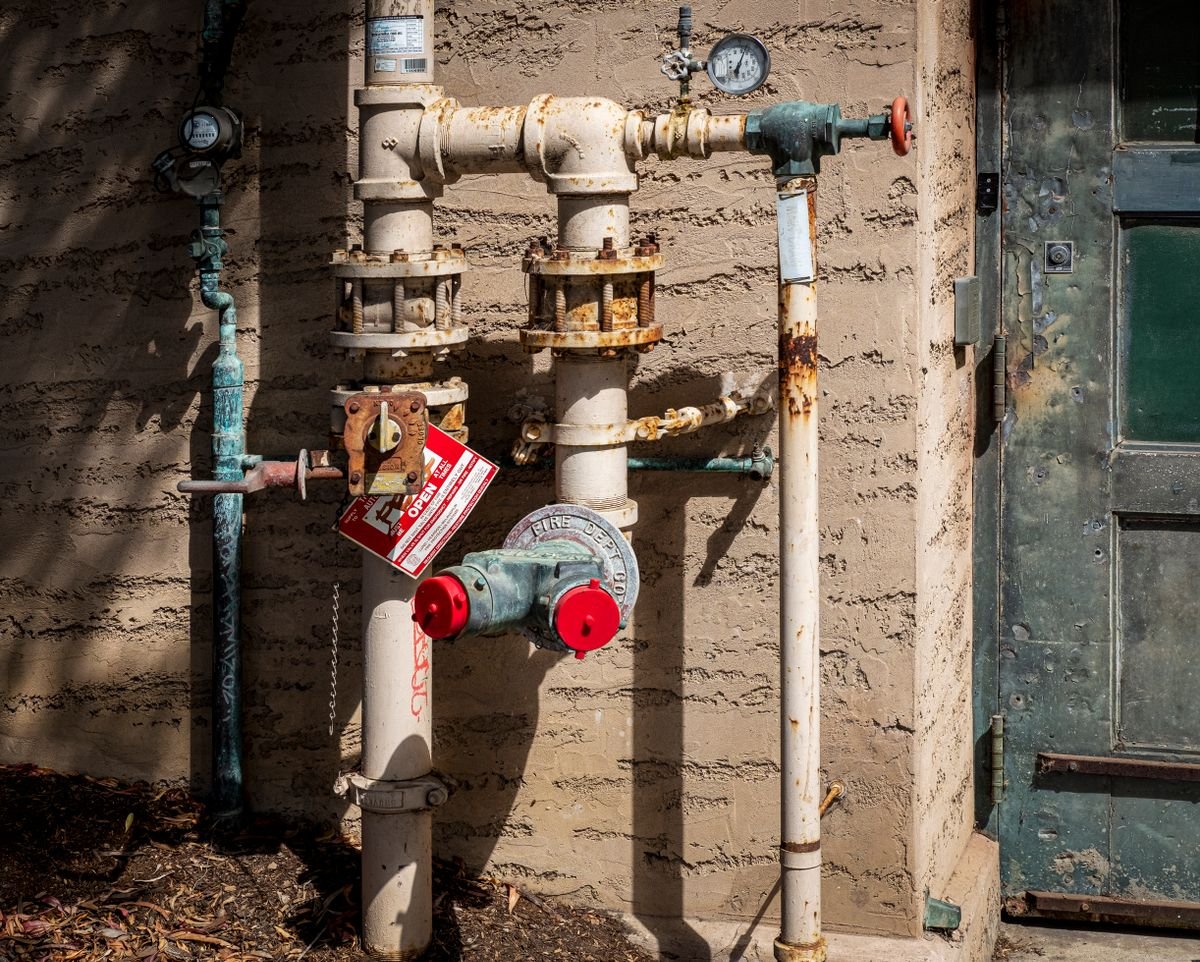 A plumber checking the stopcock and incoming water supply pipe