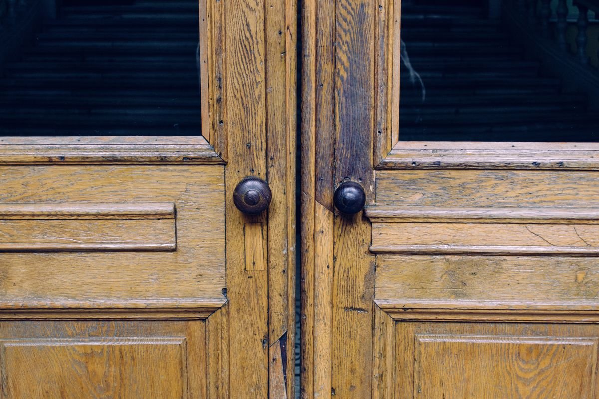 A locksmith securing a damaged front door after a break-in