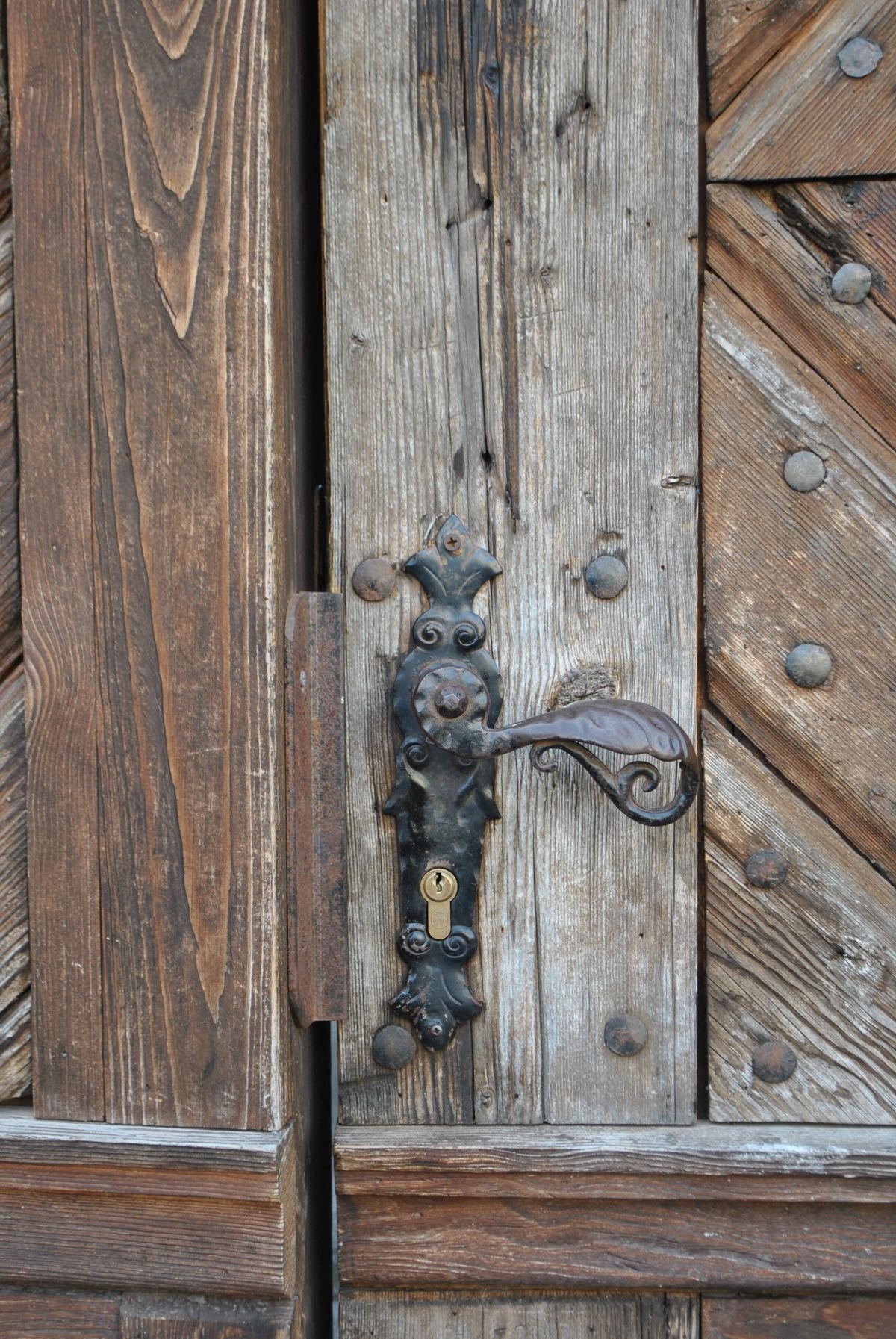 Old timber door with iron lever handle and lock