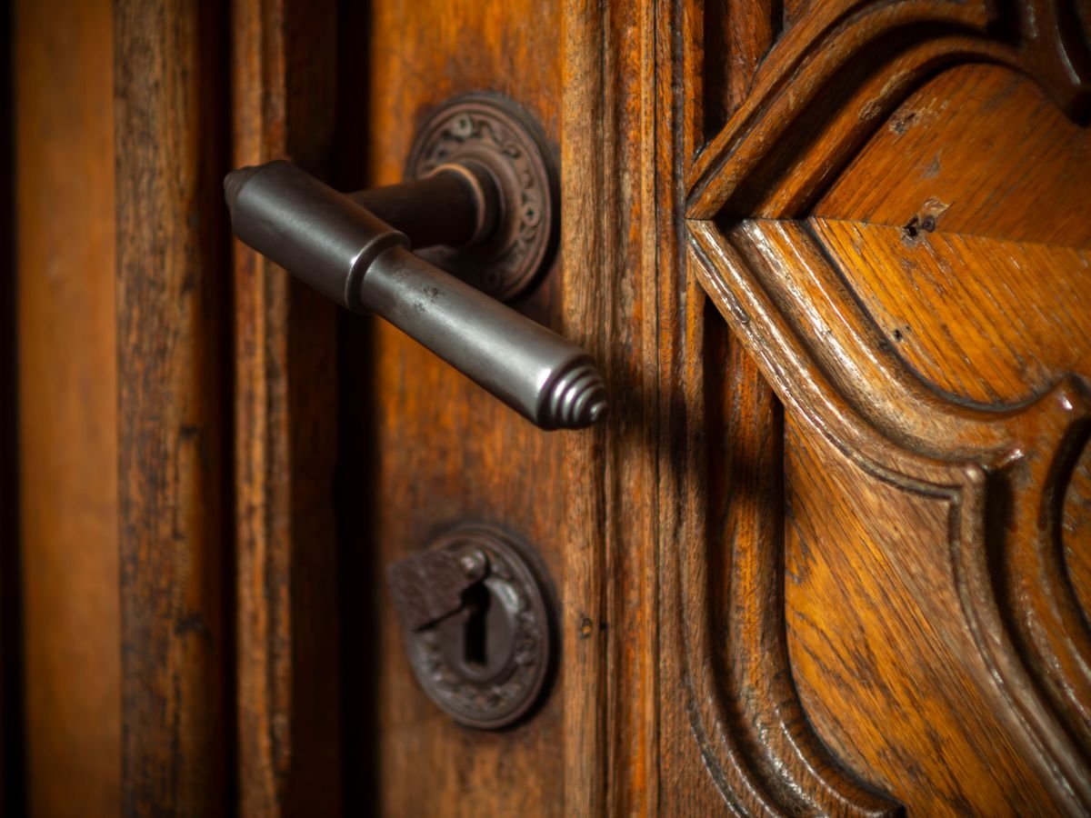 A locksmith testing a stiff multipoint door lock and handle