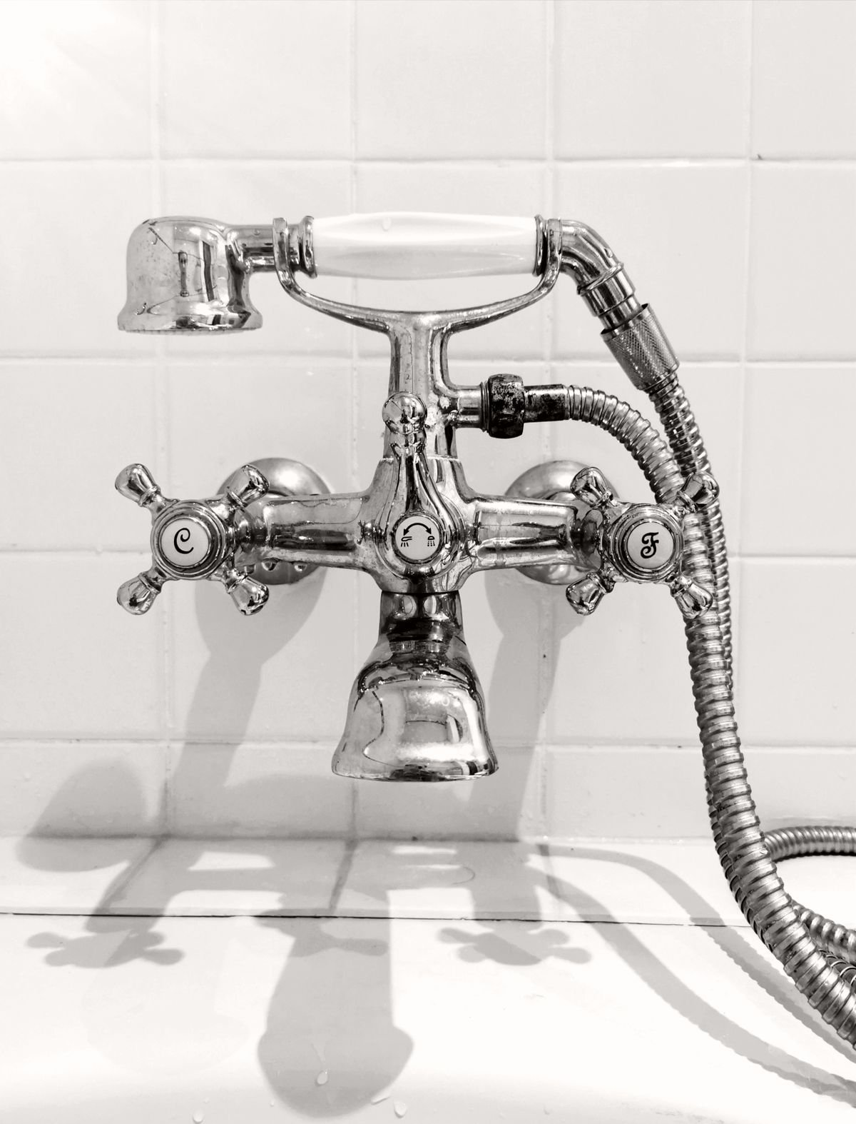 A plumber replacing the cartridge in a dripping kitchen mixer tap