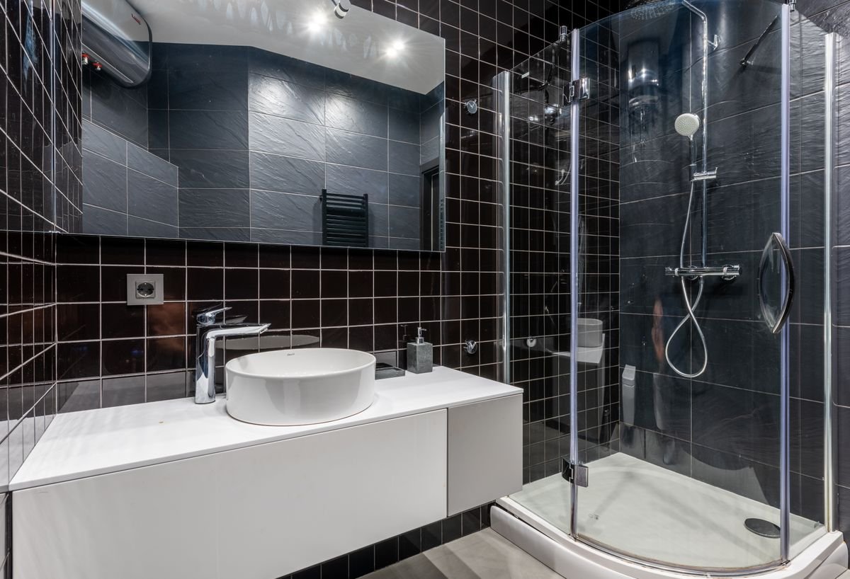 Shower leak repairs - plumber fitting a thermostatic shower valve in a modern bathroom