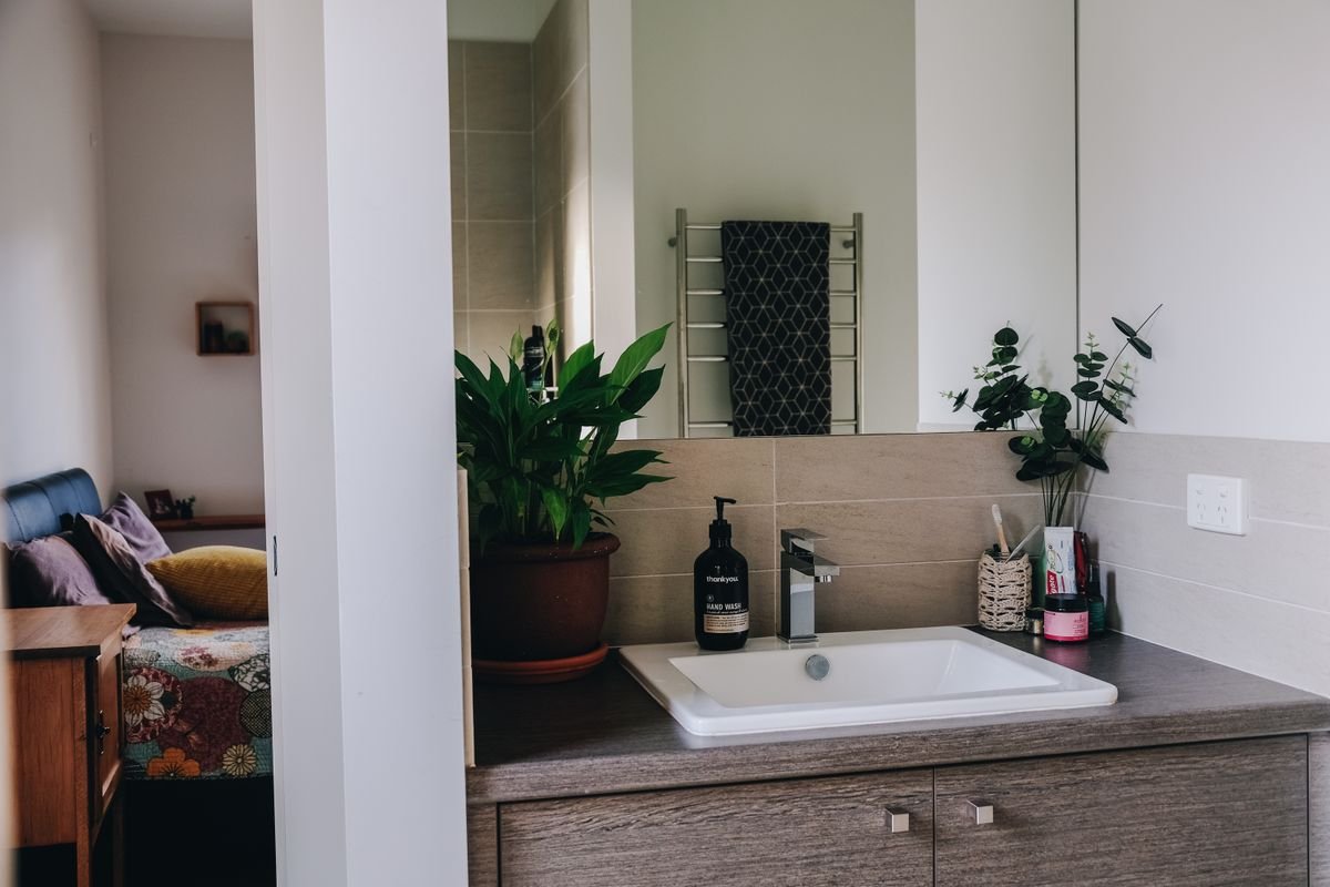 A plumber clearing a blocked toilet in a rental flat bathroom