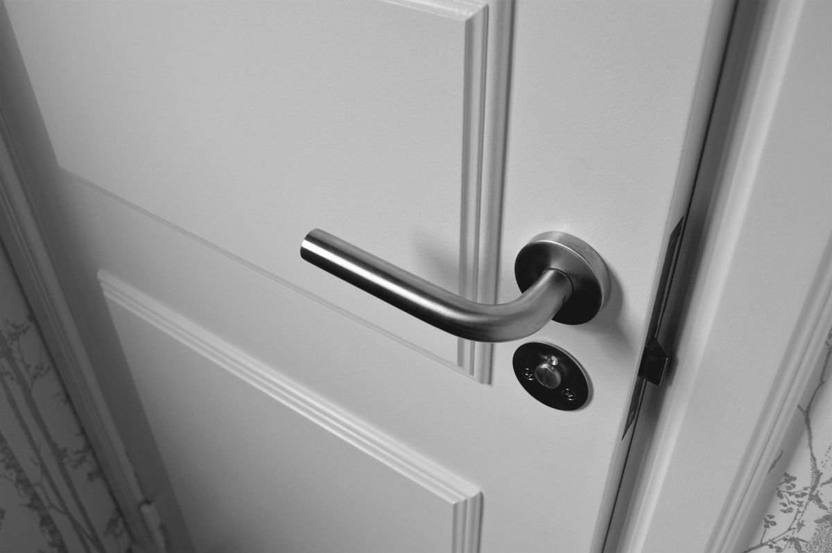 A letting agent checking a stopcock and front door lock during a property handover